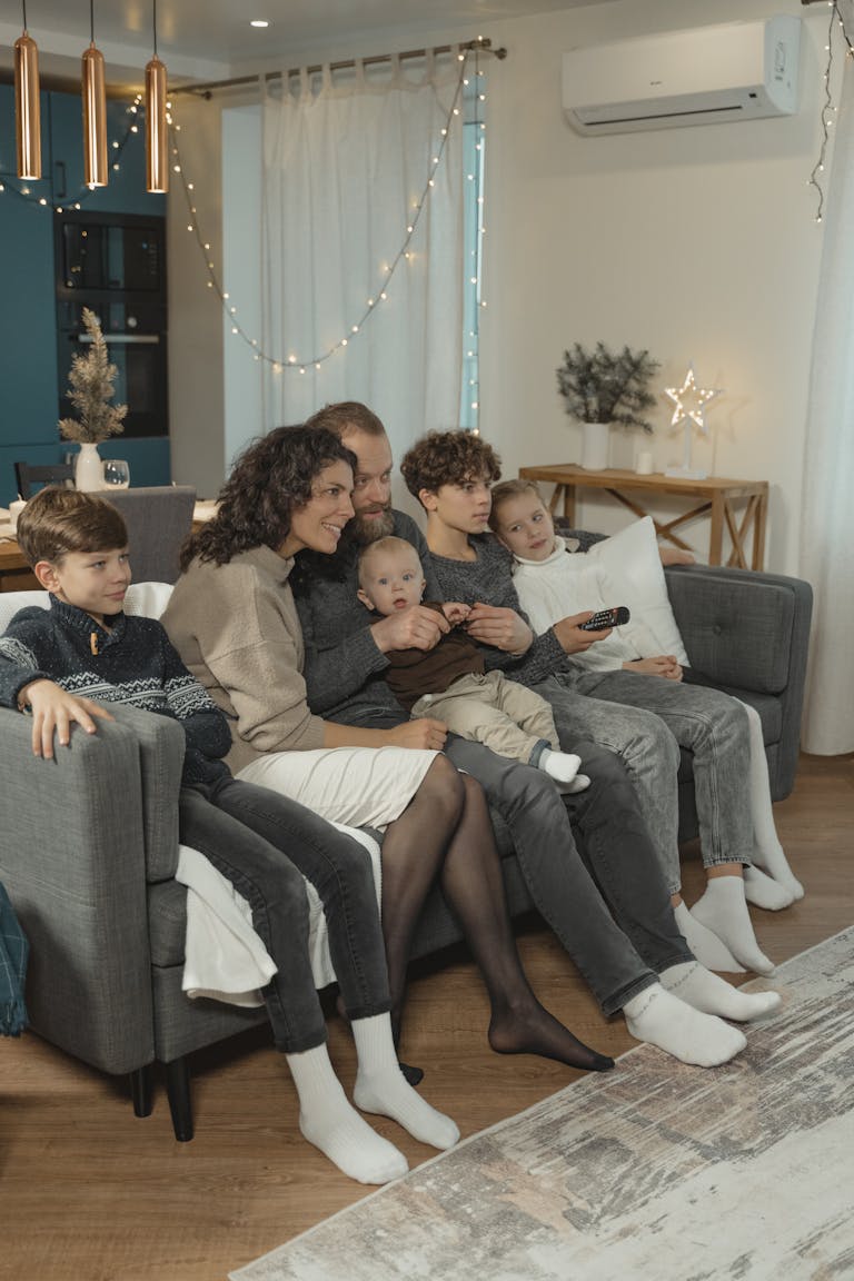 Happy family gathered on the sofa enjoying a cozy Christmas evening indoors.